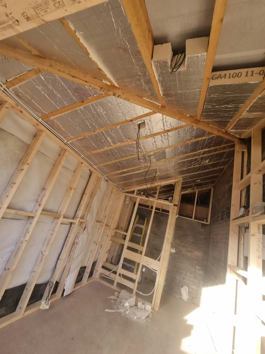 Foil-faced insulation fitted between the roof timbers, with insulated walls and new internal partitions