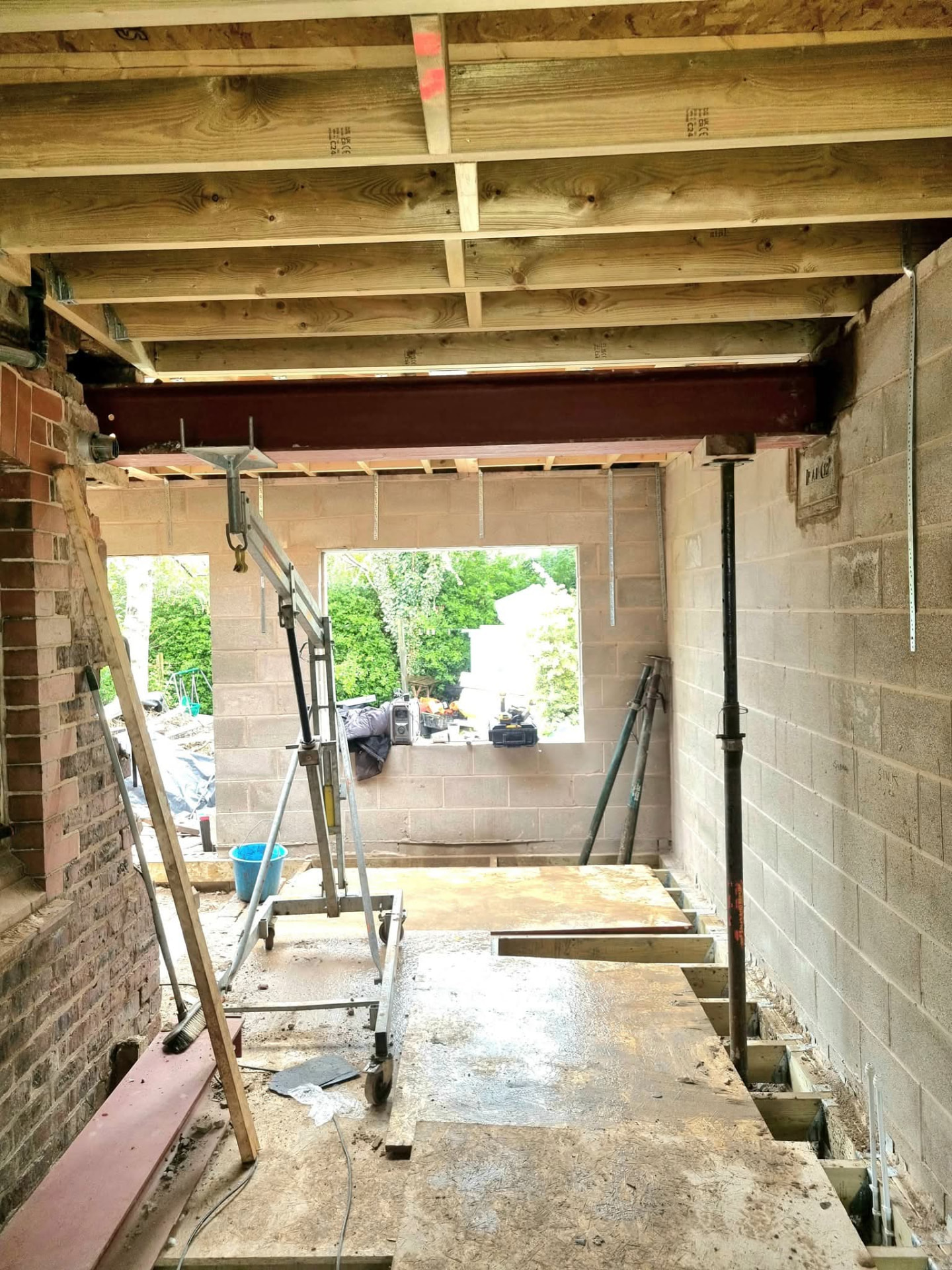 Exposed floor joists with a steel beam and temporary props
