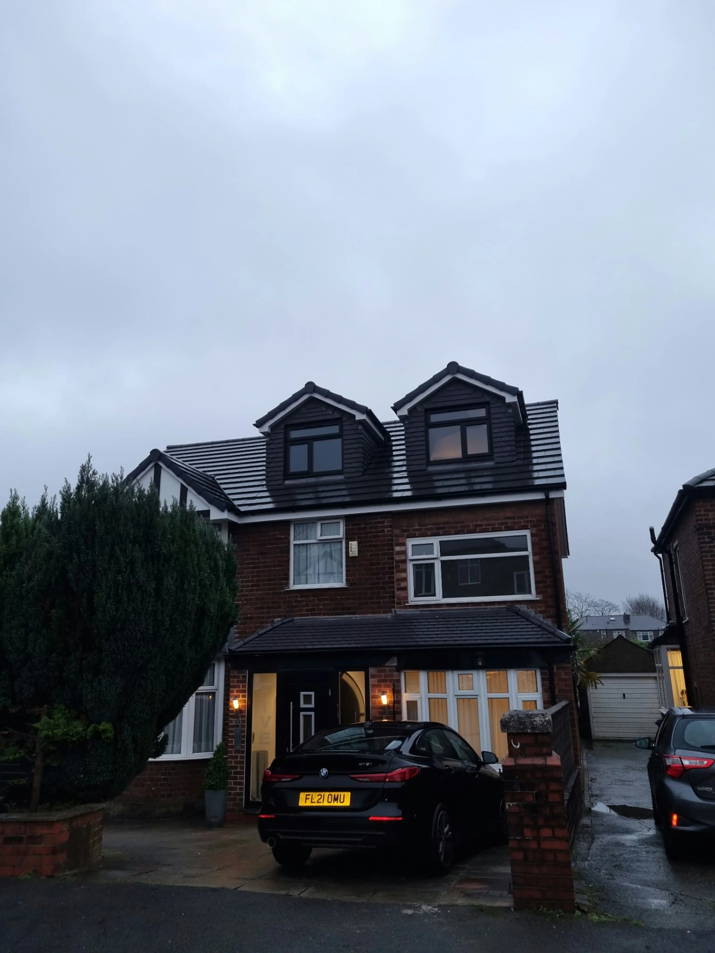 Completed detached hip-to-gable loft conversion in Prestwich with two front dormers, dark roof finishes and new windows