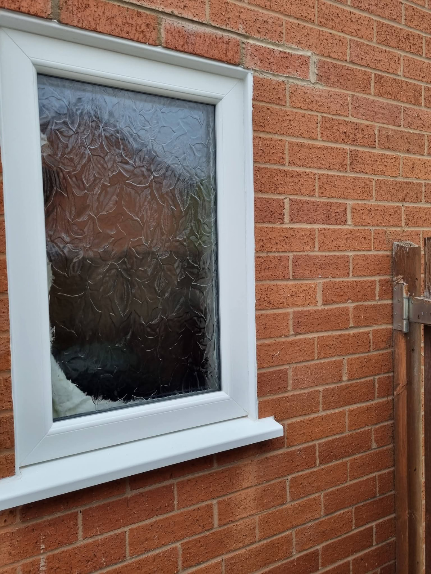 White-framed obscure-glazed window in red brickwork