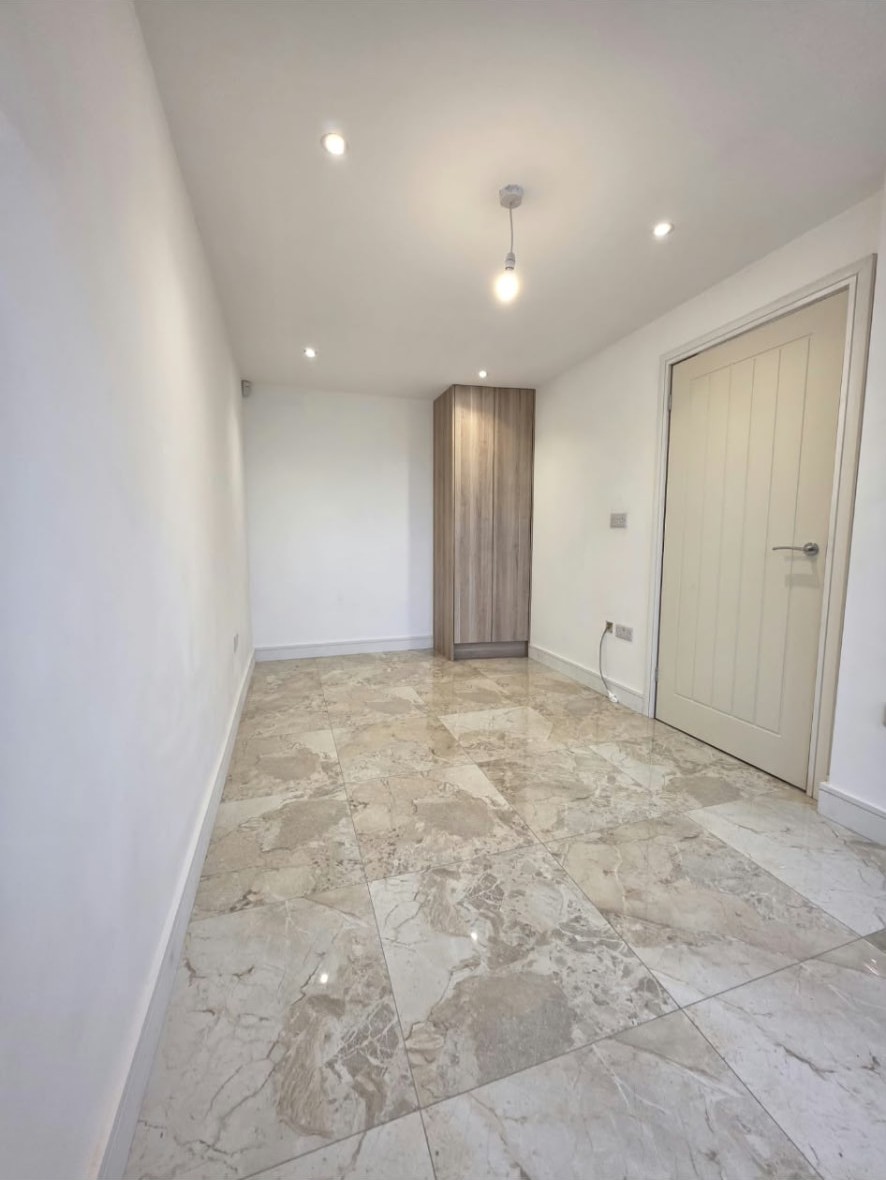 Finished Worsley home office with tiled floor, tall cupboard and panelled door