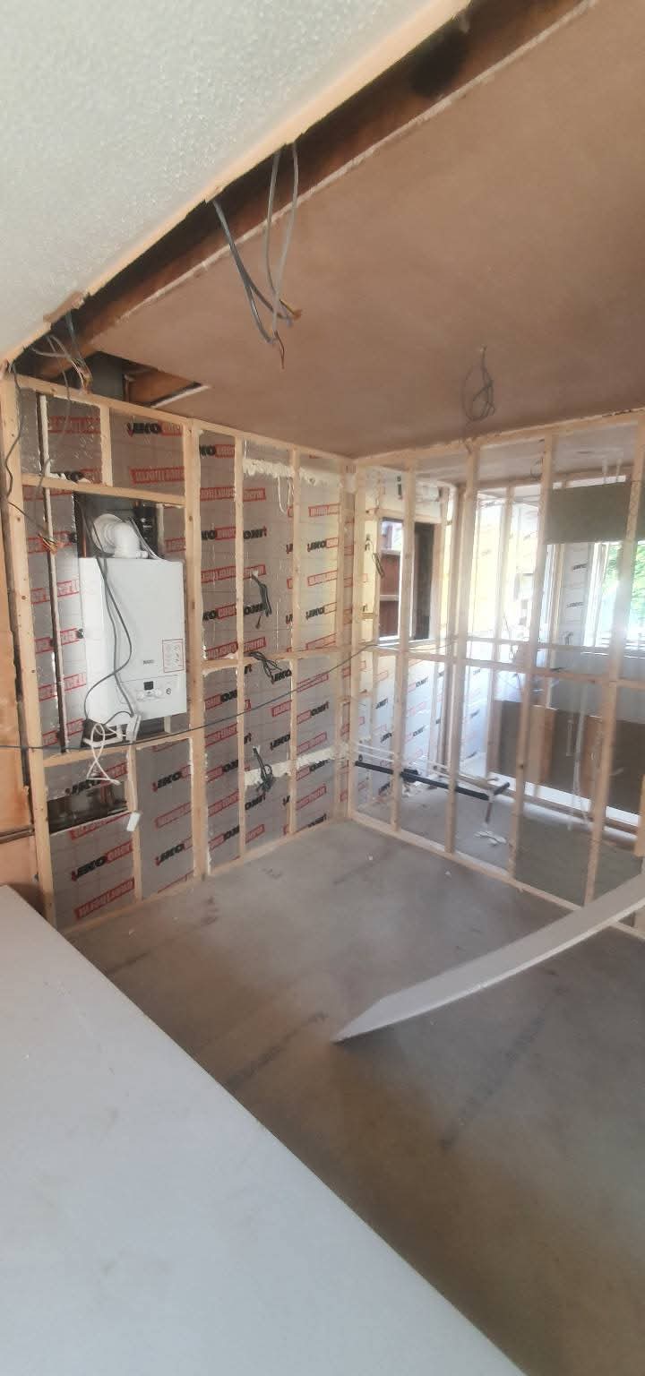 Timber stud framing and wall insulation around a boiler