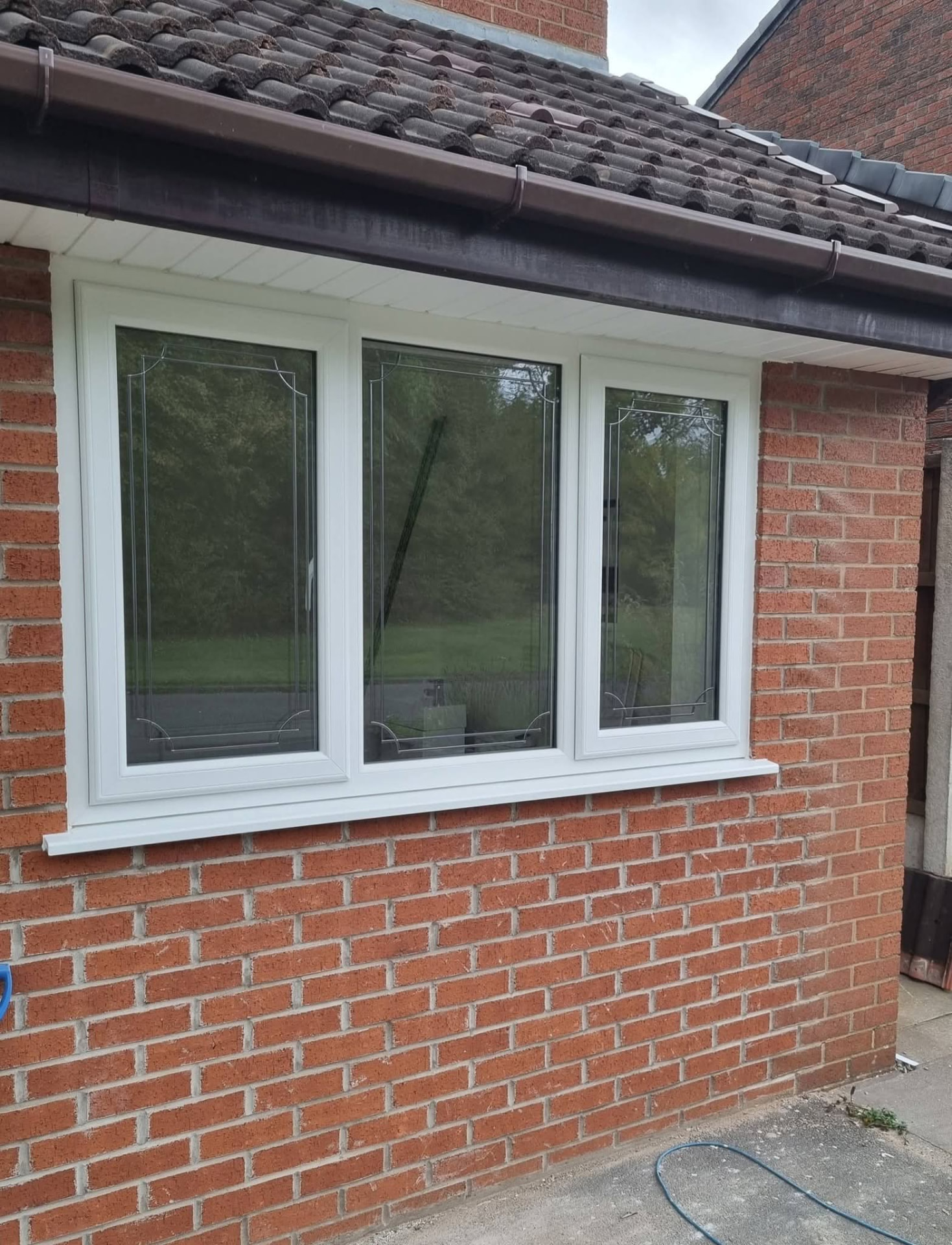 White-framed three-pane window in a brick wall