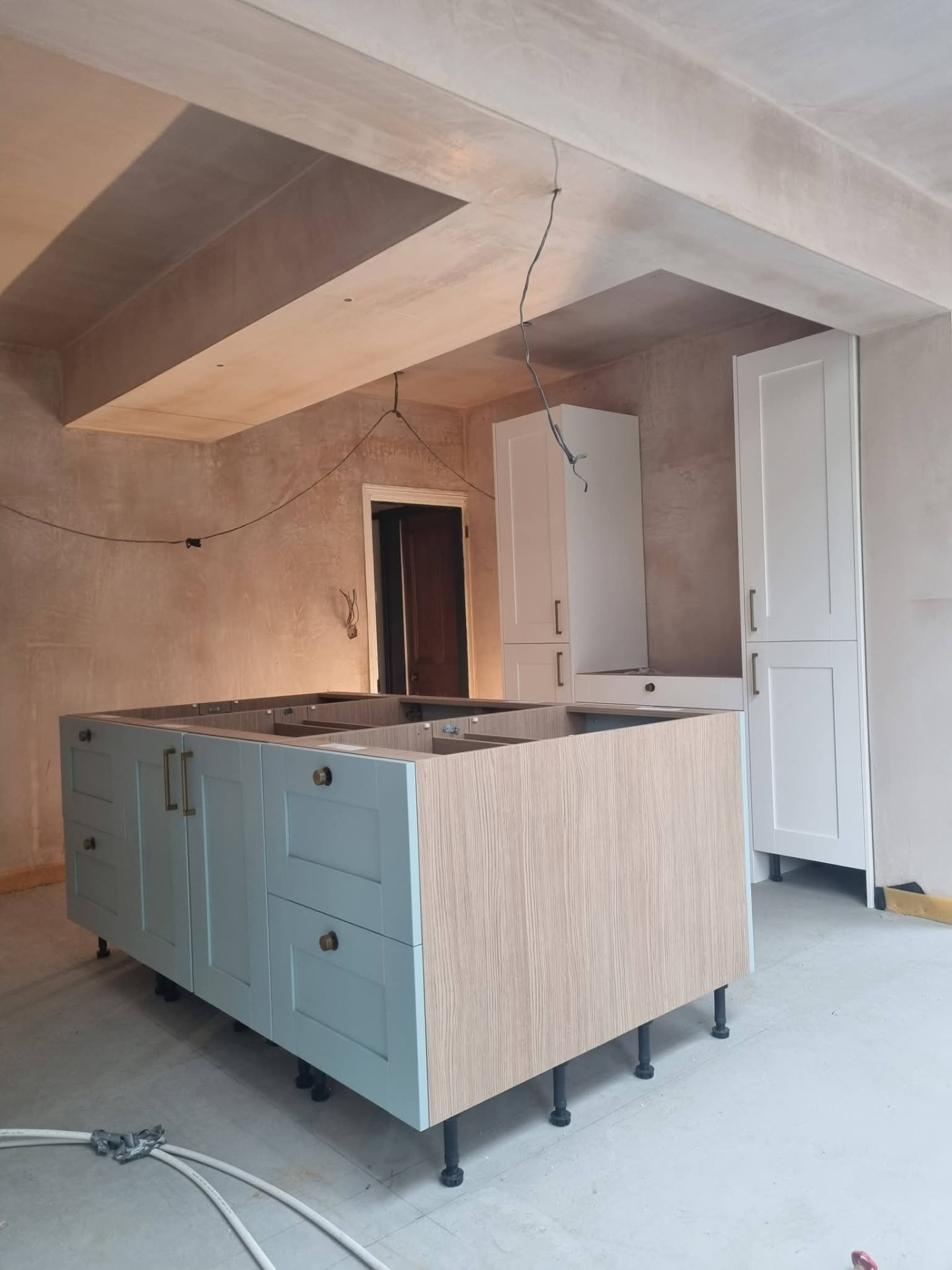 Kitchen island with blue drawer fronts during installation