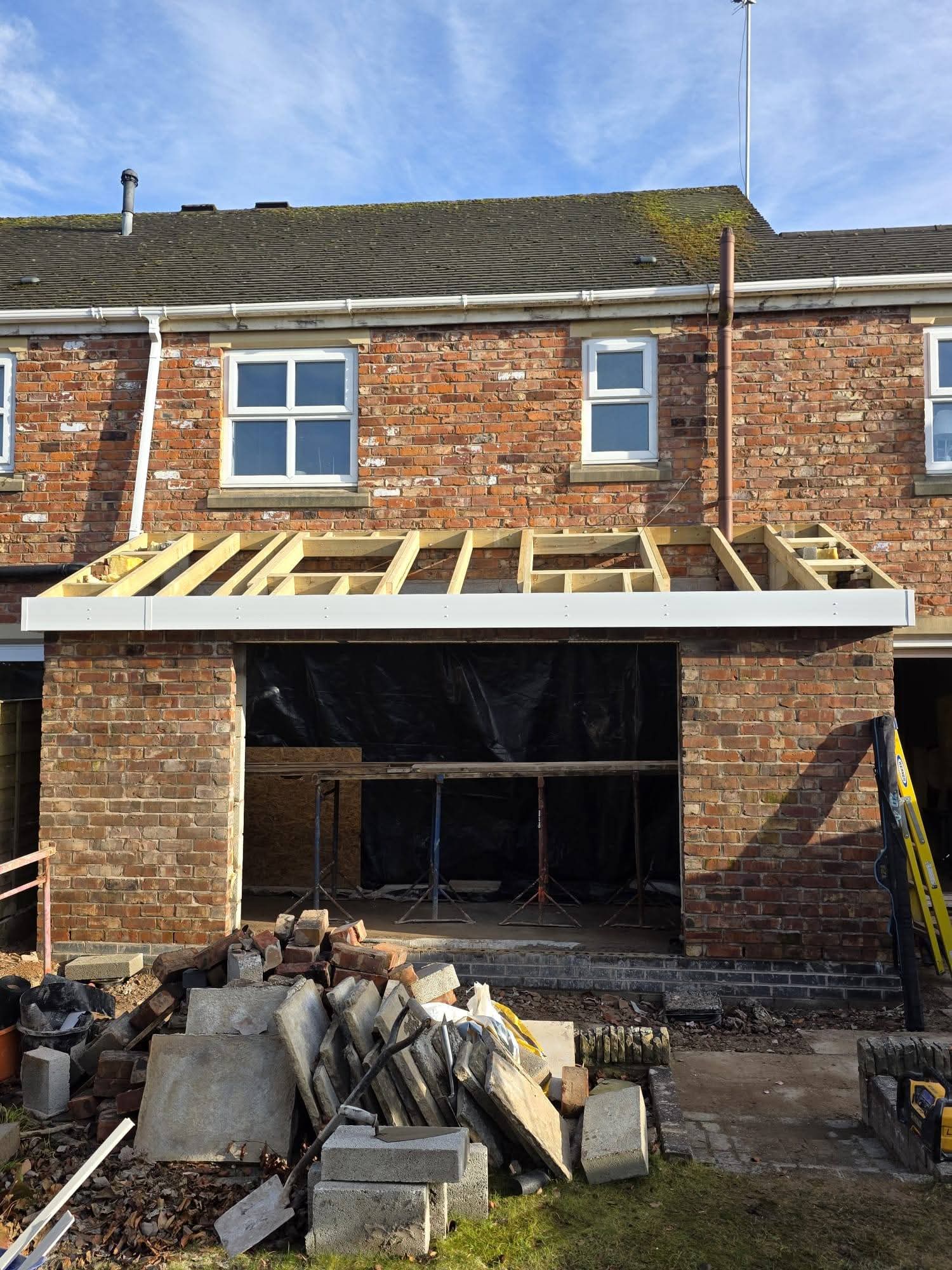 Front view of the brick extension with lean-to timber roof framing and white fascia