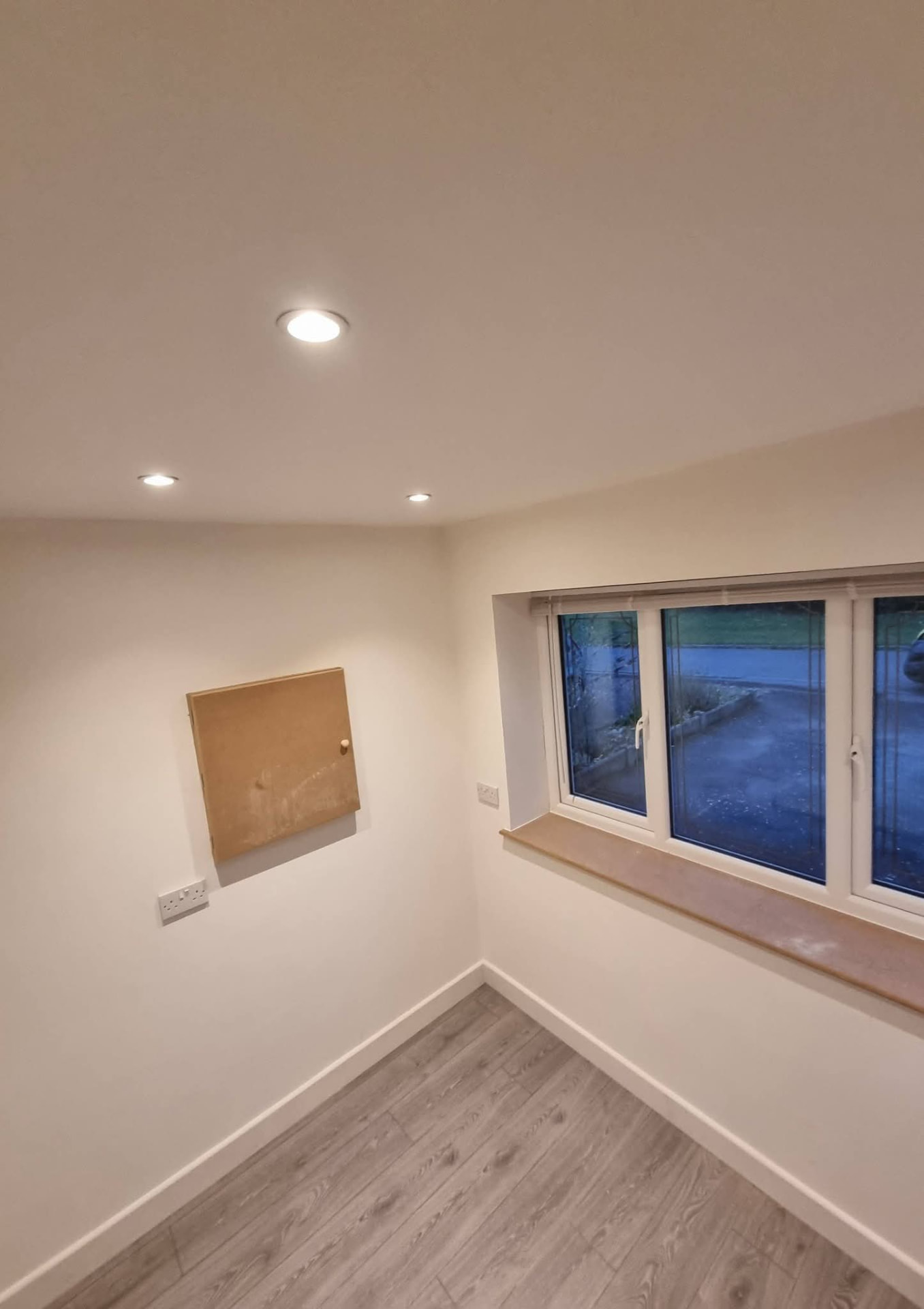 Finished room with recessed ceiling lights and a wide window